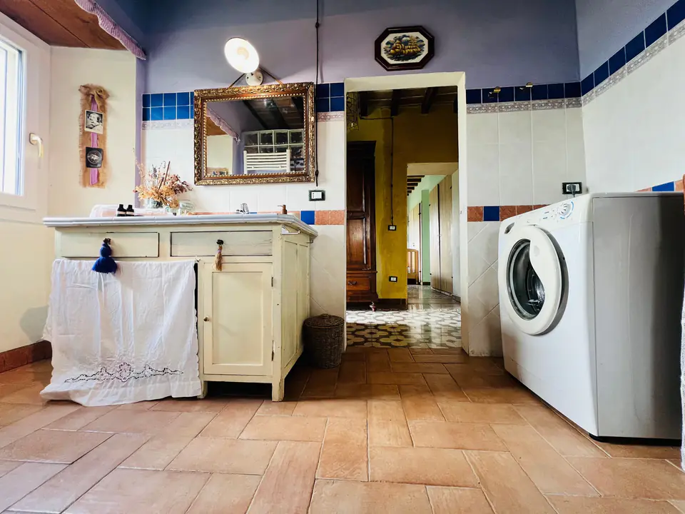 Bagno di Casa Vedetta con lavatrice, mobile in legno e specchio