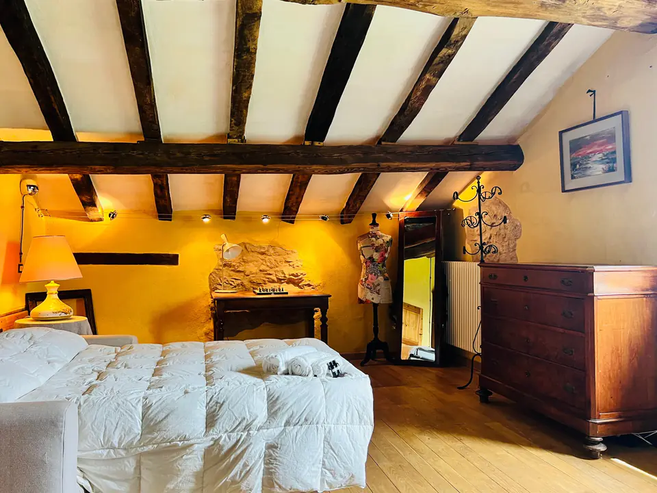 Camera da letto di Casa Vedetta illuminata da luce calda con mobili in legno antico