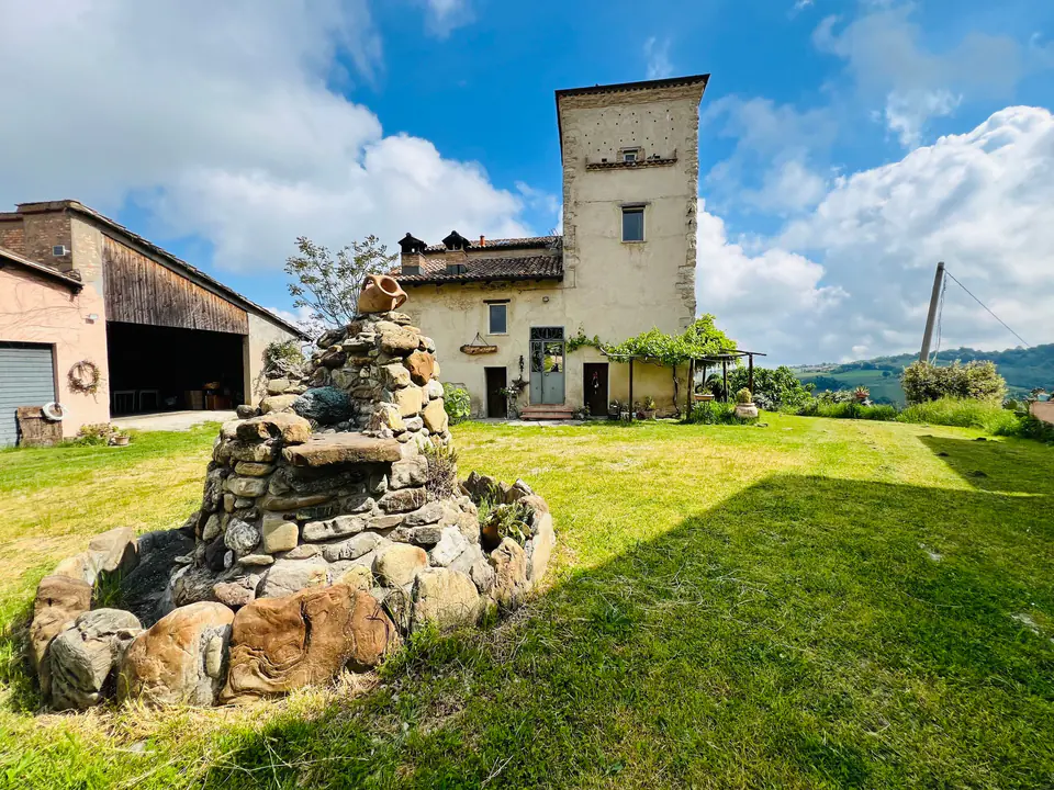 Fontana in pietra nel prato davanti al rustico di Casa Vedetta