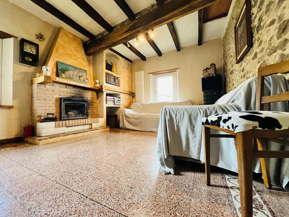 Sala relax con camino, doppio divano e travi a vista a Casa Vedetta