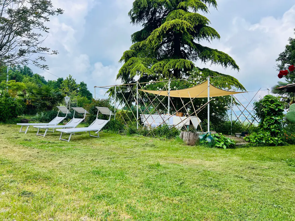 Lettini prendisole e gazebo nel giardino privato di Casa Vedetta circondato da alberi
