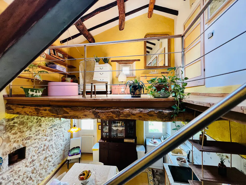 Soppalco con salottino e ringhiera in legno affacciato sul soggiorno di Casa Vedetta