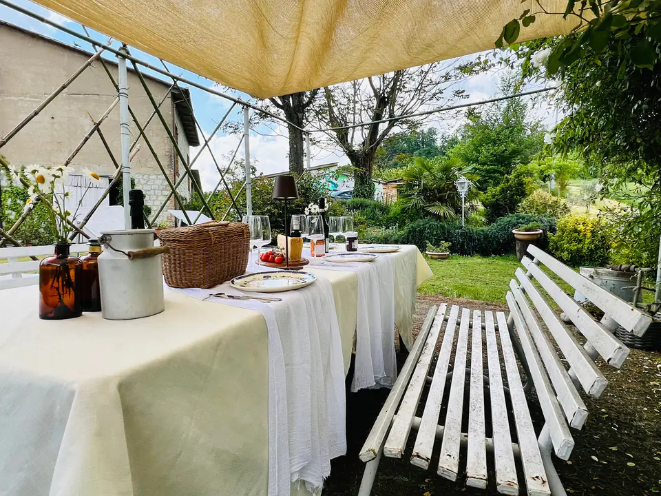 Tavolo lungo apparecchiato sotto il gazebo nel giardino di Casa Vedetta