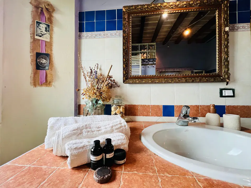 Vasca da bagno con set di cortesia e specchio dorato a Casa Vedetta